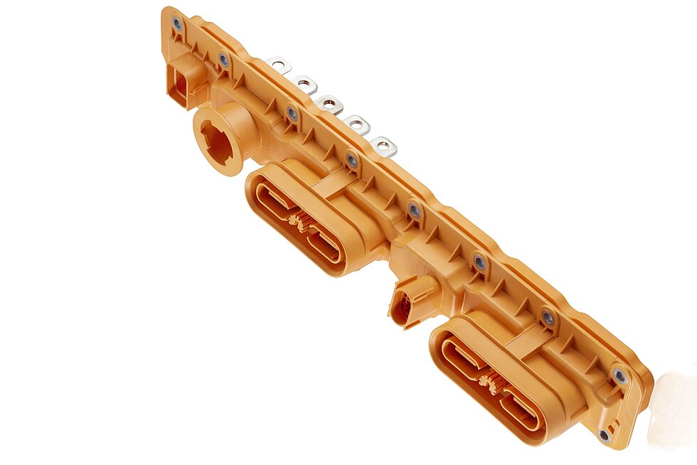 Mit Inserttechnik hergestelltes, orangefarbenes Spritzgussteil mit Metalleinleger